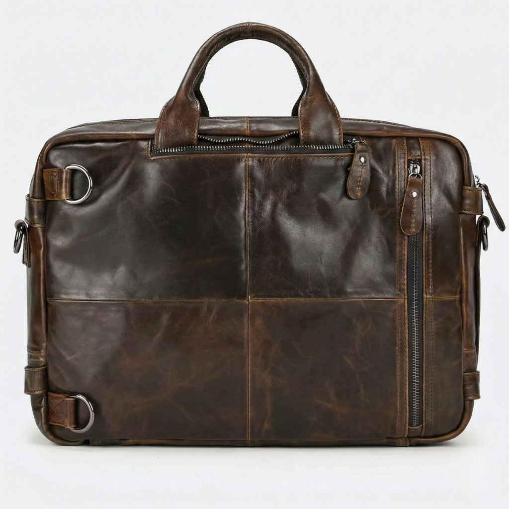 Verso du sac en cuir marron chocolat, quatre sections assemblées, attaches de bretelles et zip latéral