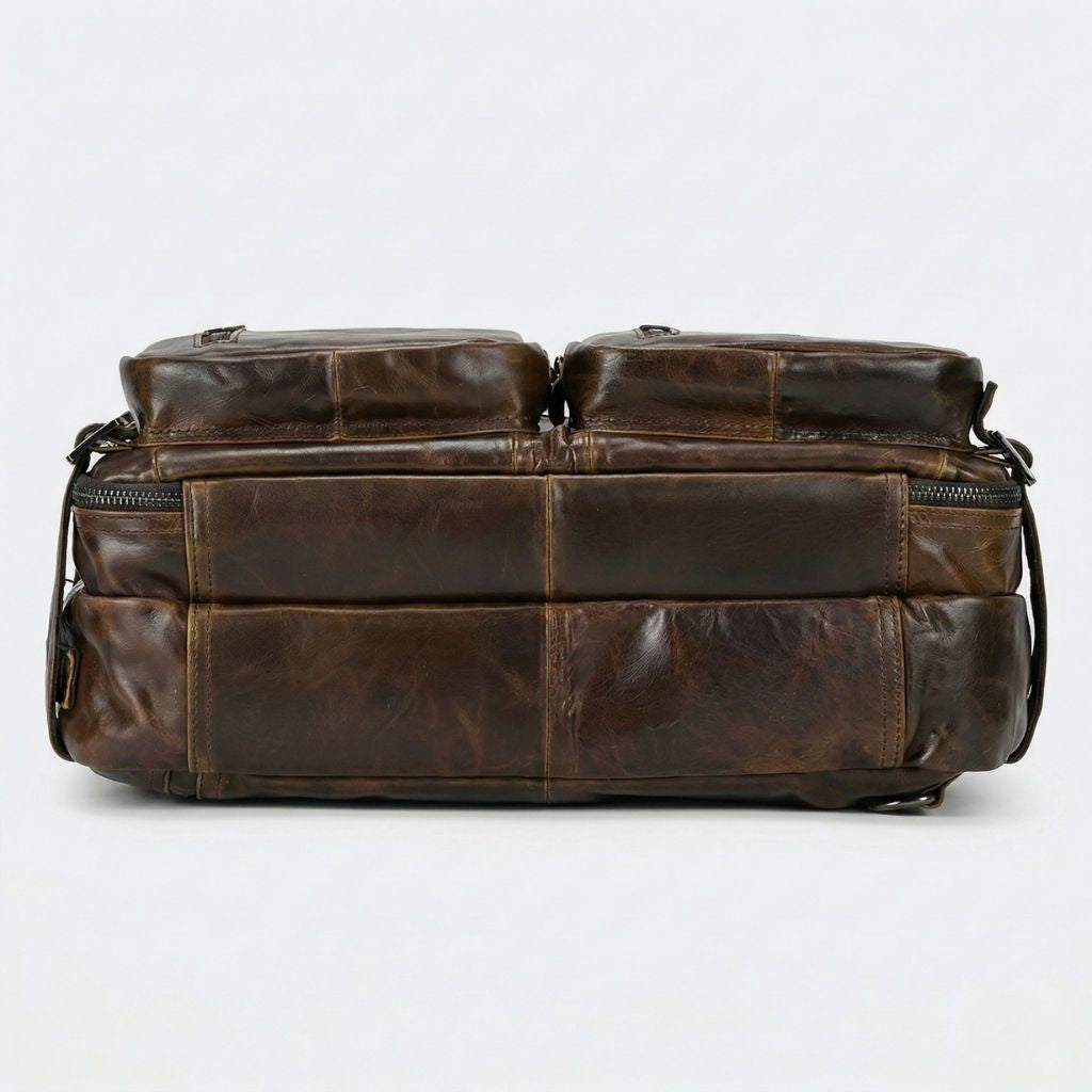 Dessous du sac en cuir marron vintage, panneaux assemblés à coutures apparentes et forte patine naturelle