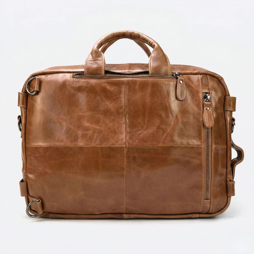 Dos du sac cabine en cuir cognac, quatre panneaux cousus, anneaux de bretelles et zip latéral droit