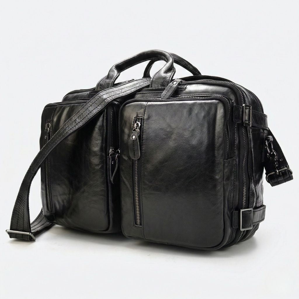 Sac cabine convertible en cuir noir brillant huilé, deux poches avant et bandoulière noire, quincaillerie gunmetal