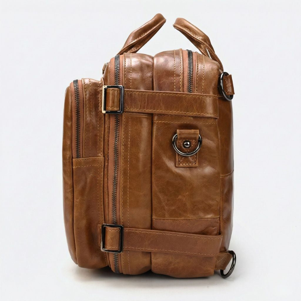 Profil droit du sac cabine cognac, fermeture latérale verticale et boucles de compression gunmetal