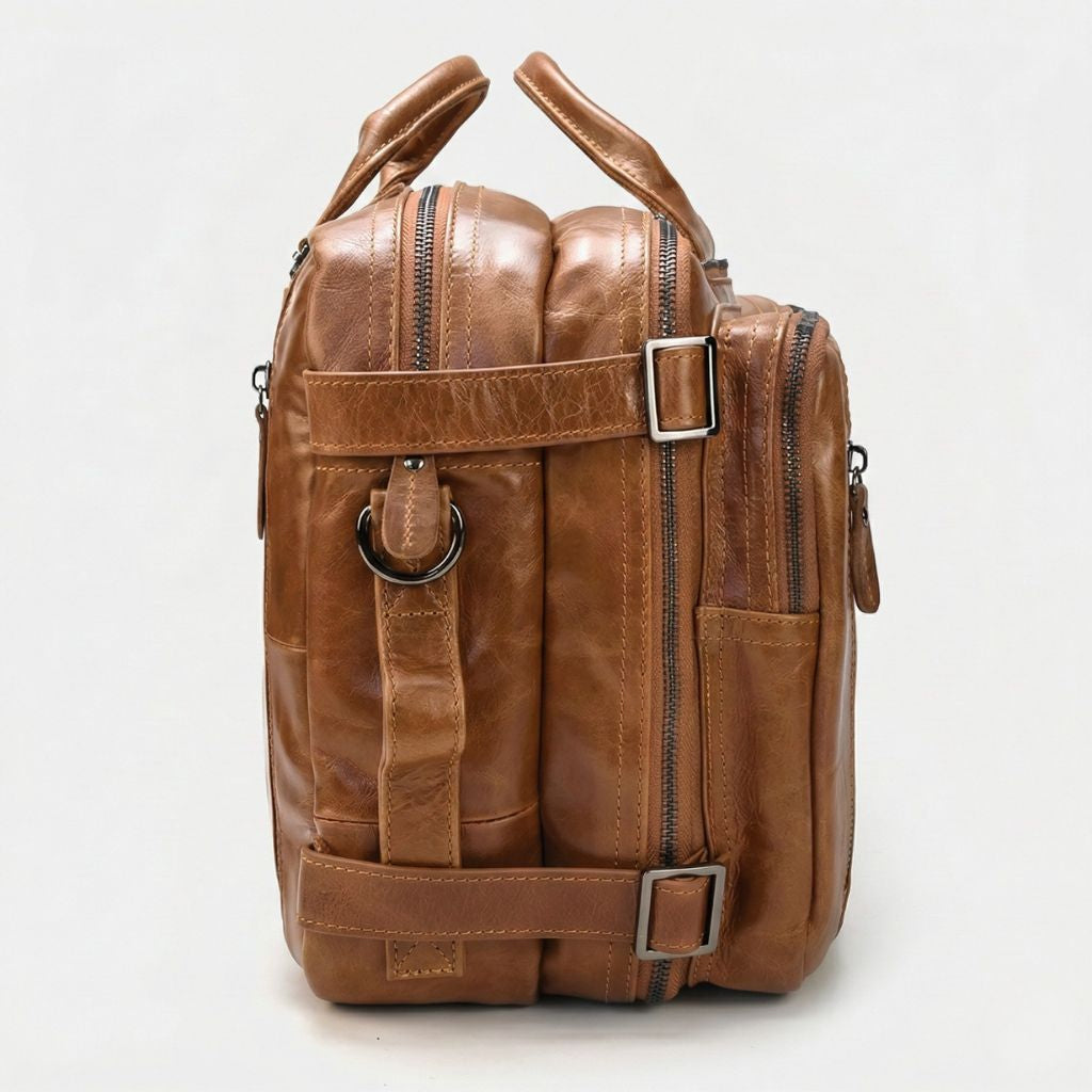 Profil gauche en cuir cognac huilé, bretelles de sac à dos réglables avec boucles rectangulaires grises