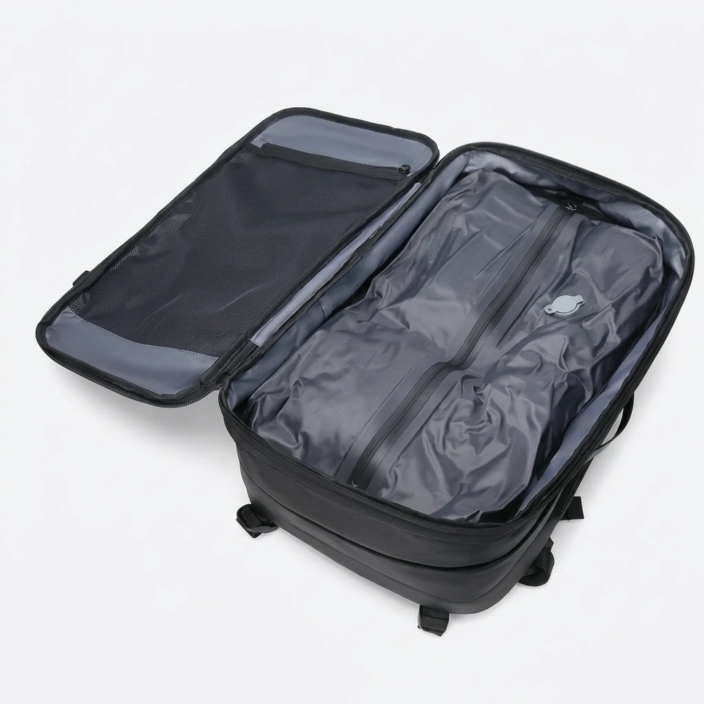 Sac à dos voyage noir ouvert à plat avec sac de compression à valve et poche filet sur le rabat