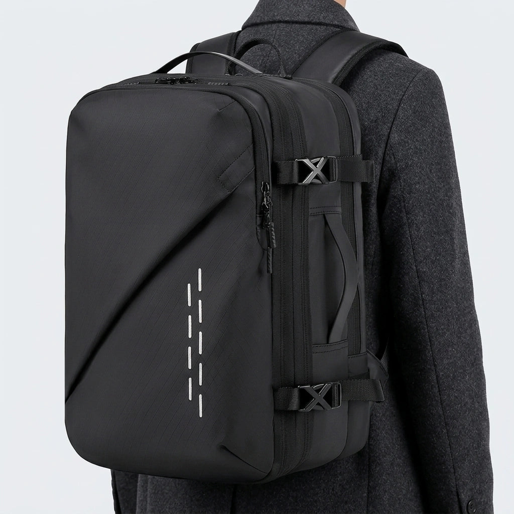 Homme en manteau gris portant le sac à dos voyage noir avec bandes réfléchissantes sur une épaule
