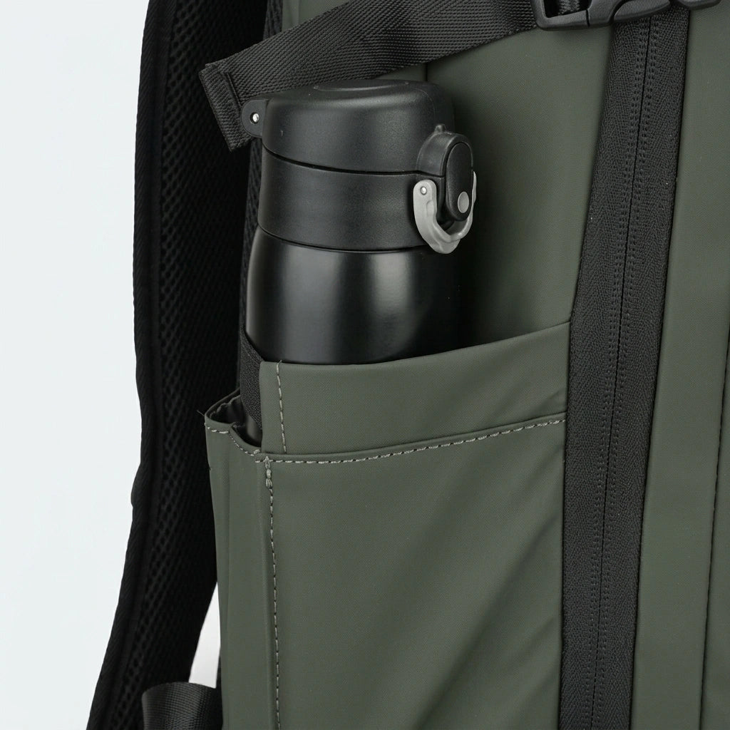 Détail de la poche latérale du sac à dos voyage vert avec gourde isotherme noire rangée à l'intérieur
