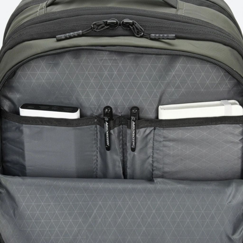 Détail de la poche organiseur frontale avec stylos, batterie externe et carnet rangés dans les poches