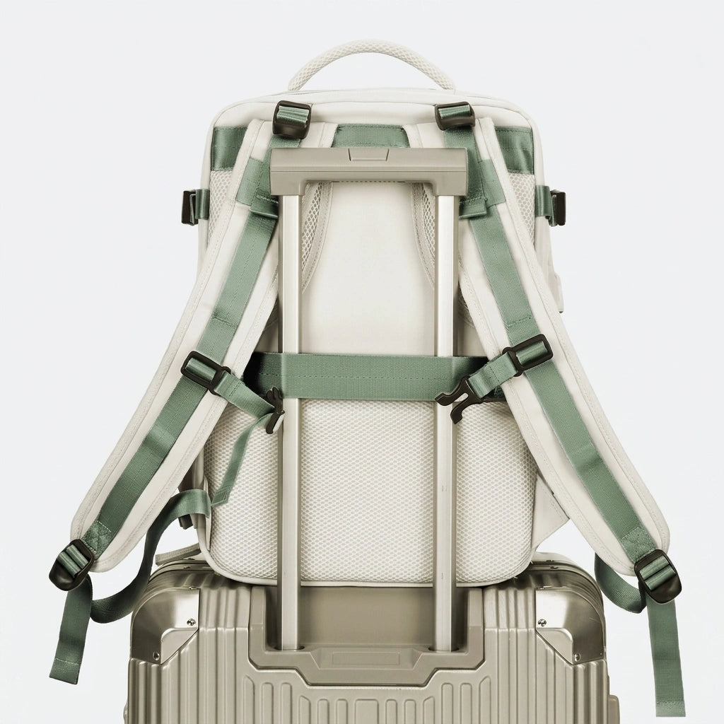 Vue arrière du sac à dos de voyage beige fixé sur une valise à roulettes grâce à la sangle trolley intégrée