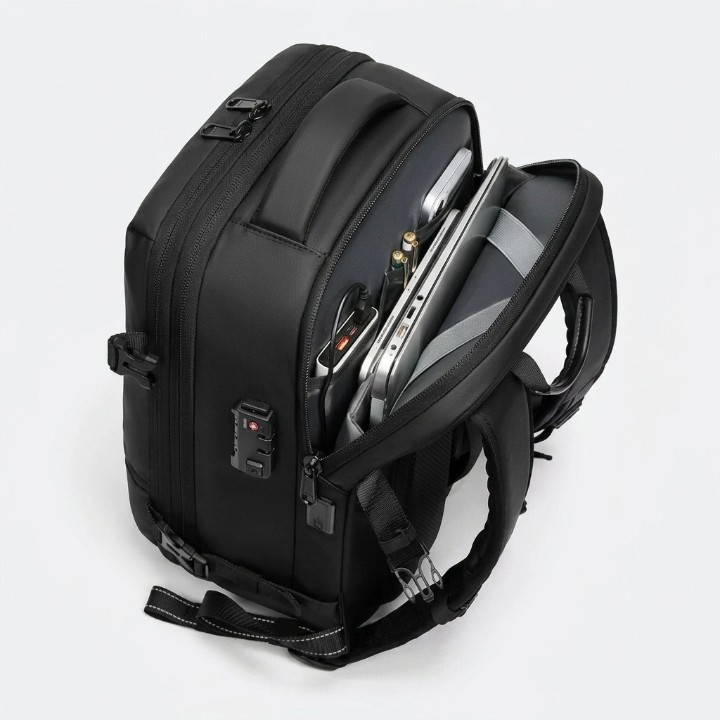 Vue latérale du sac à dos de voyage noir ouvert montrant le compartiment laptop et le cadenas TSA rouge