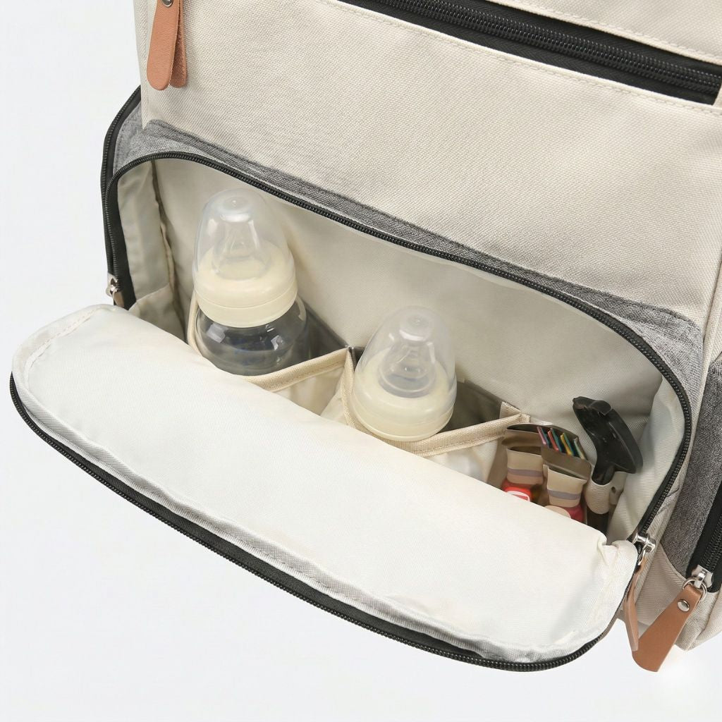 Poche frontale ouverte d'un sac à langer bicolore accueillant deux biberons, une tétine et accessoires bébé Image