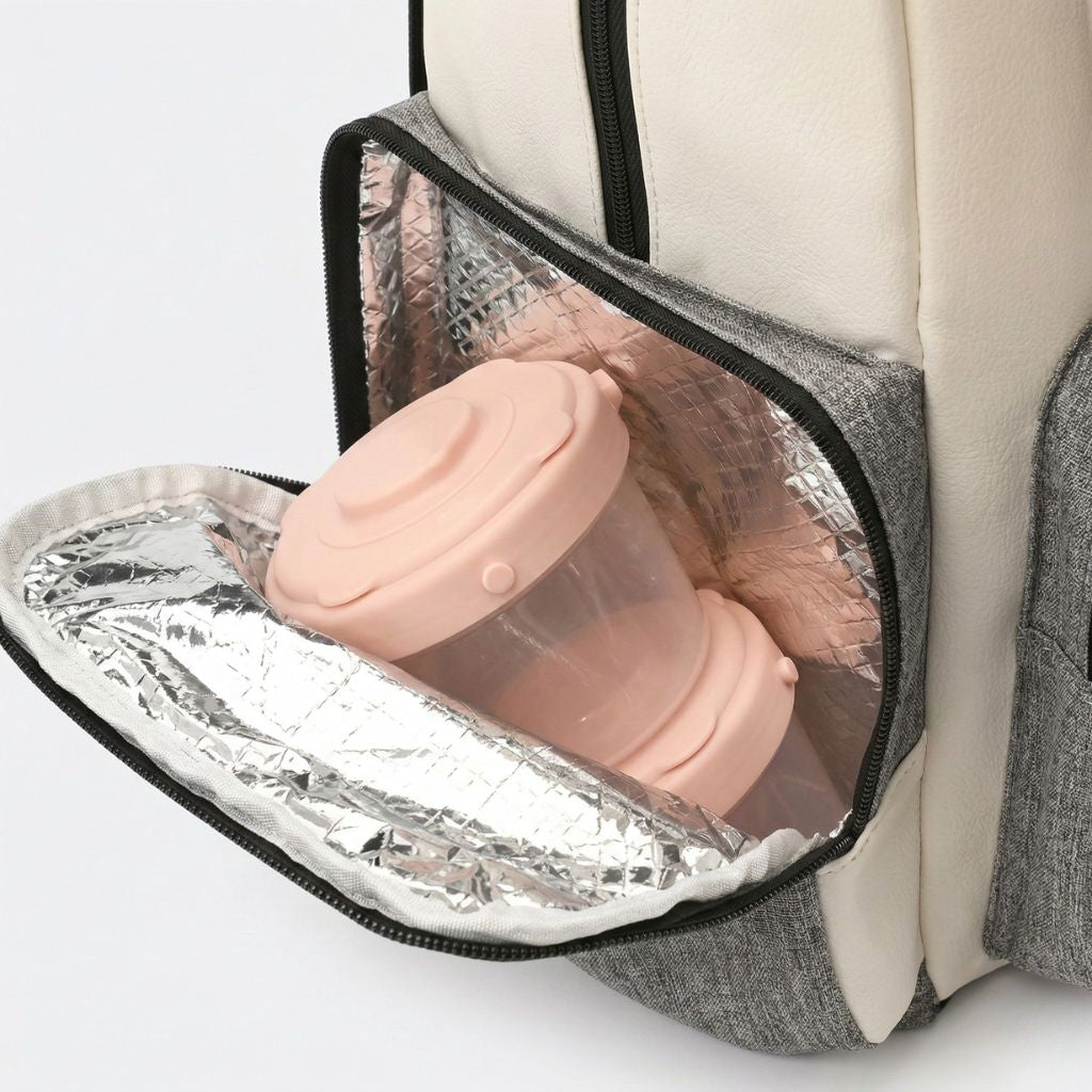 Poche isotherme intégrée du sac à langer ouverte avec deux biberons roses maintenus au chaud ou au froid