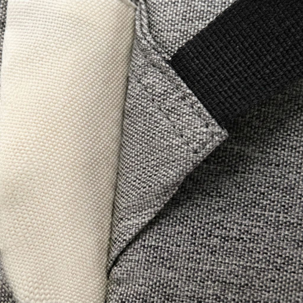 Gros plan du tissu gris chiné et du tissu beige crème contrastés du sac à langer, double matière résistante