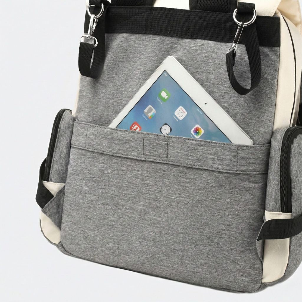 Grande poche frontale du sac à langer avec une tablette numérique insérée, accès facile et rangement sécurisé
