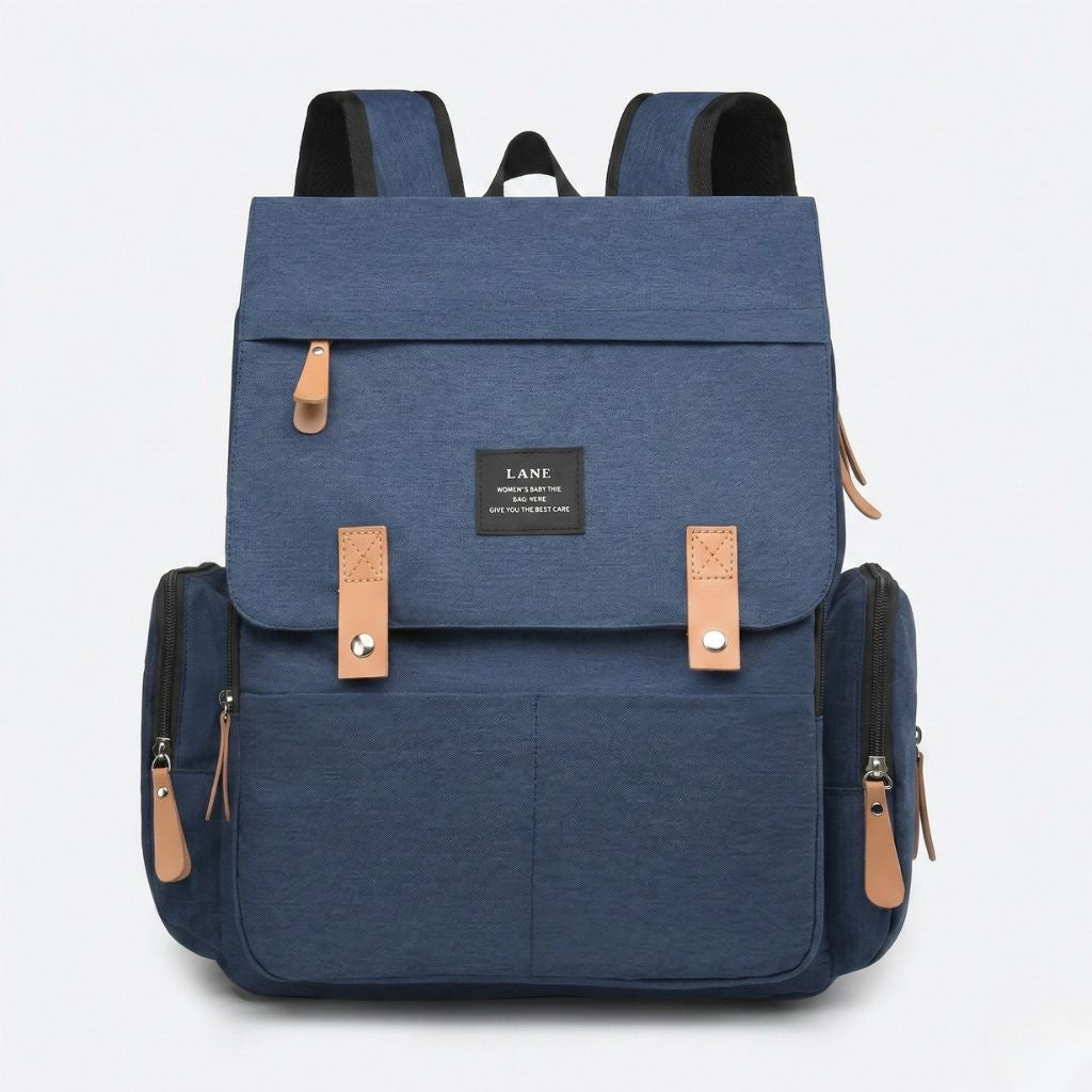 Sac à langer bleu marine, vue frontale, grand rabat avec passants cuir, poche frontale et bretelles noires