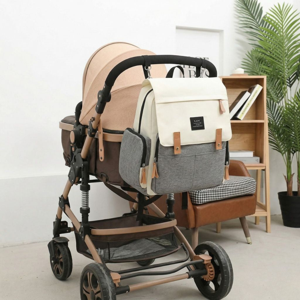 Femme portant le sac à dos à langer beige crème et gris de dos, format généreux pour les mamans actives