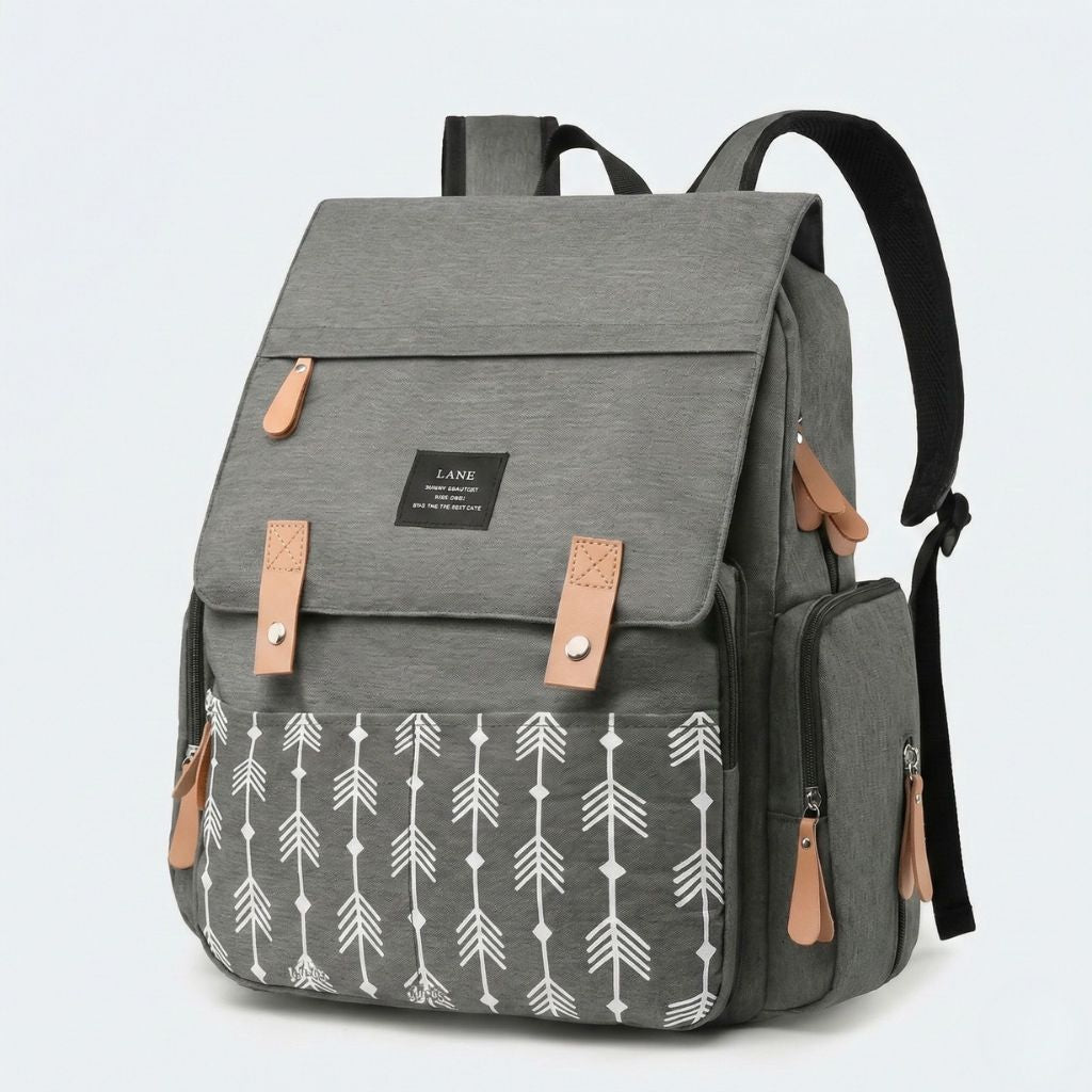 Sac à dos à langer gris chiné avec motif flèches blanches, vue 3/4, poche isotherme latérale et bretelles noires