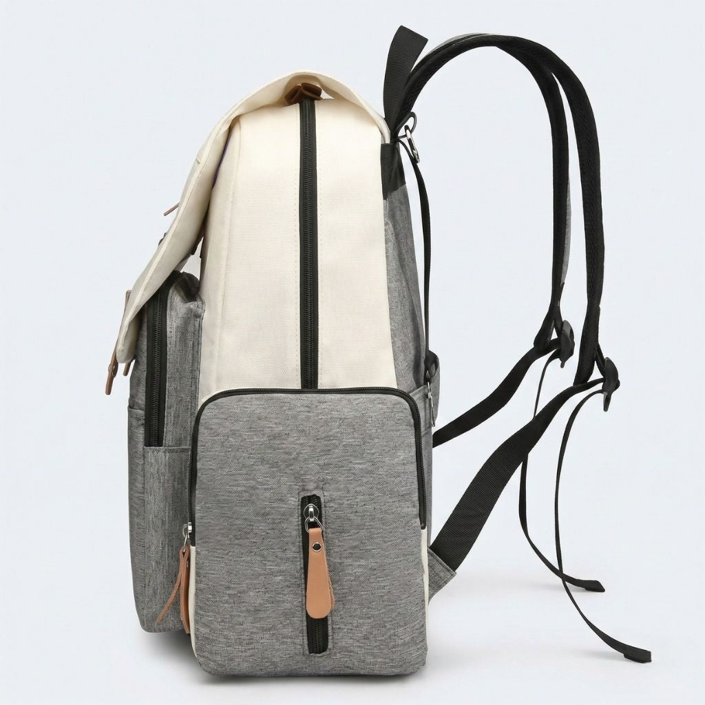 Vue latérale du sac à dos à langer bicolore gris et beige crème, bretelles réglables et poches latérales zippées