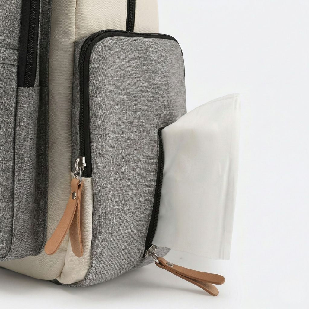 Poche isotherme latérale du sac à langer ouverte révélant un tapis de change plié blanc prêt à l'emploi