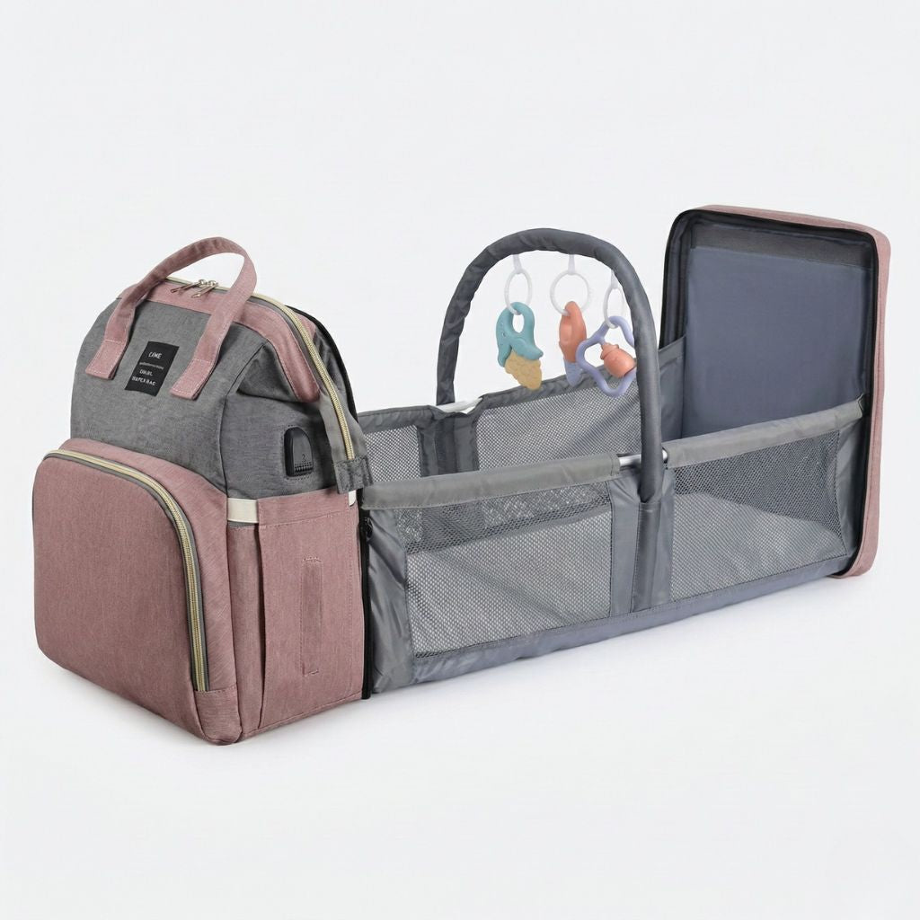 Berceau déployable du sac à langer rose poudré avec arche jouets colorée, matelas blanc et filets gris