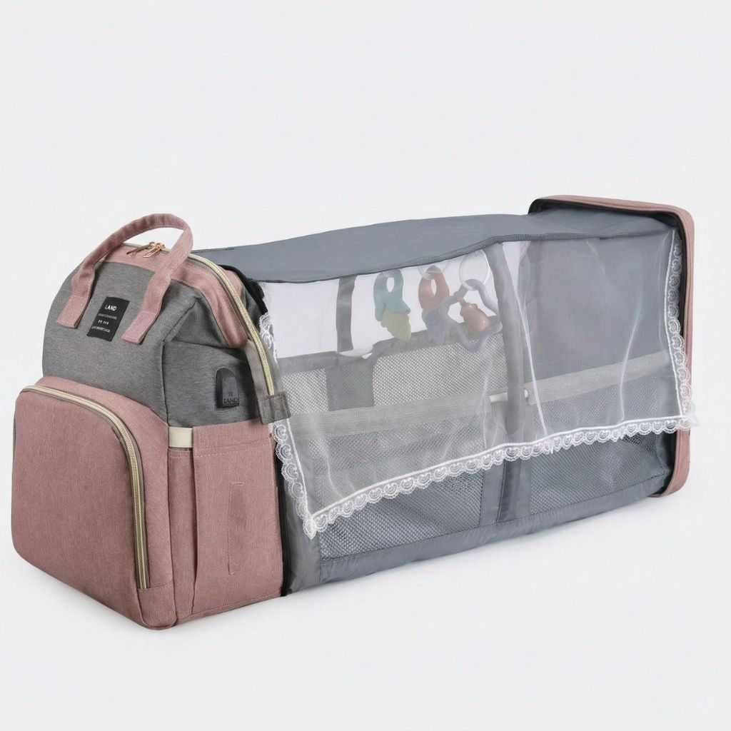 Sac à langer rose et gris transformé en lit bébé portable avec moustiquaire intégrée déployée Image