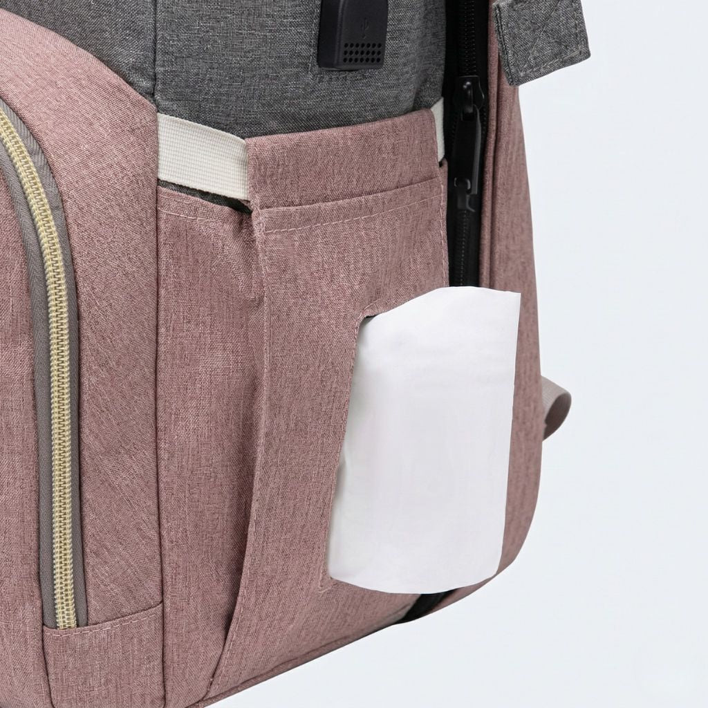 Gros plan de la poche latérale du sac rose poudré avec distributeur de lingettes intégré sortant