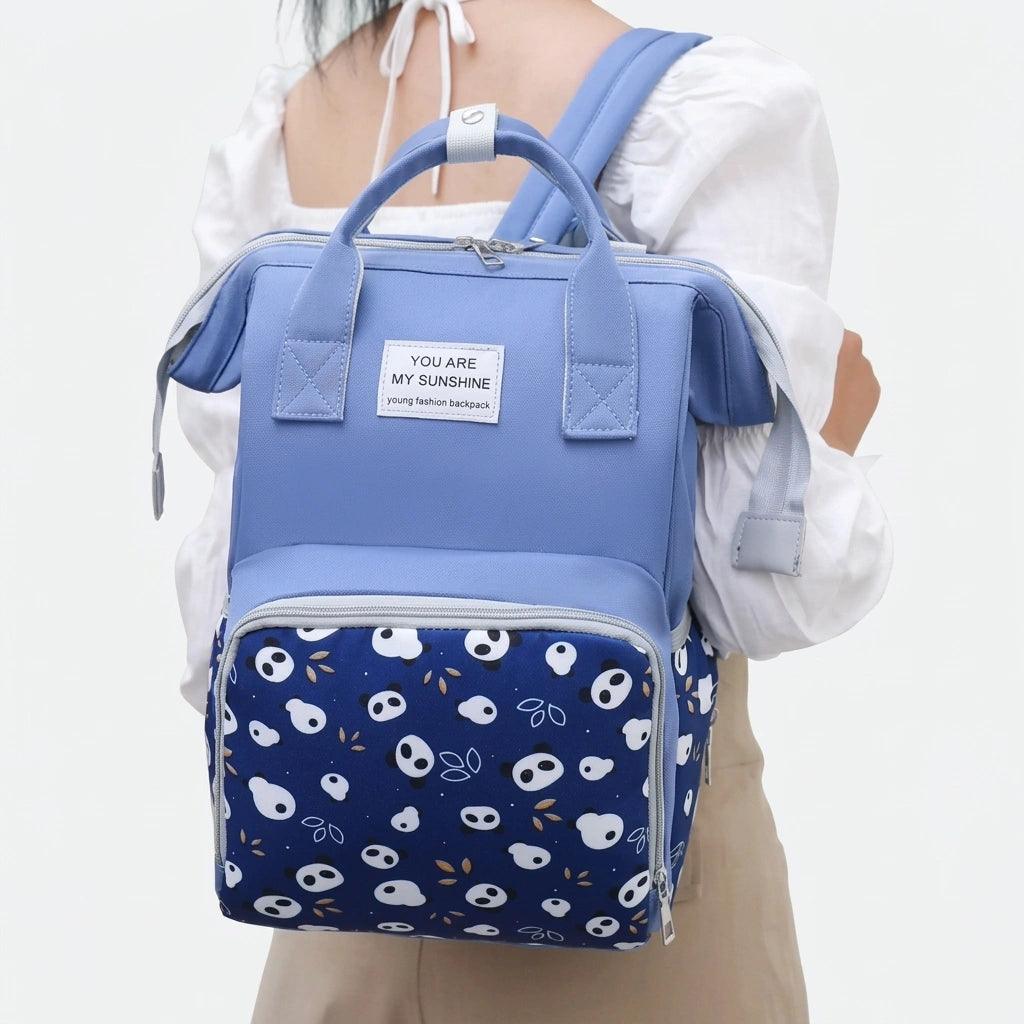 Sac à dos à langer bleu marine imprimé pandas porté sur le dos par une femme, bretelles réglables