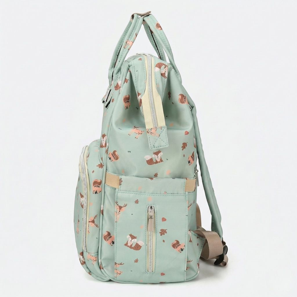Vue latérale du sac à langer vert sauge, motif renards et écureuils, avec poche latérale zippée et bretelles