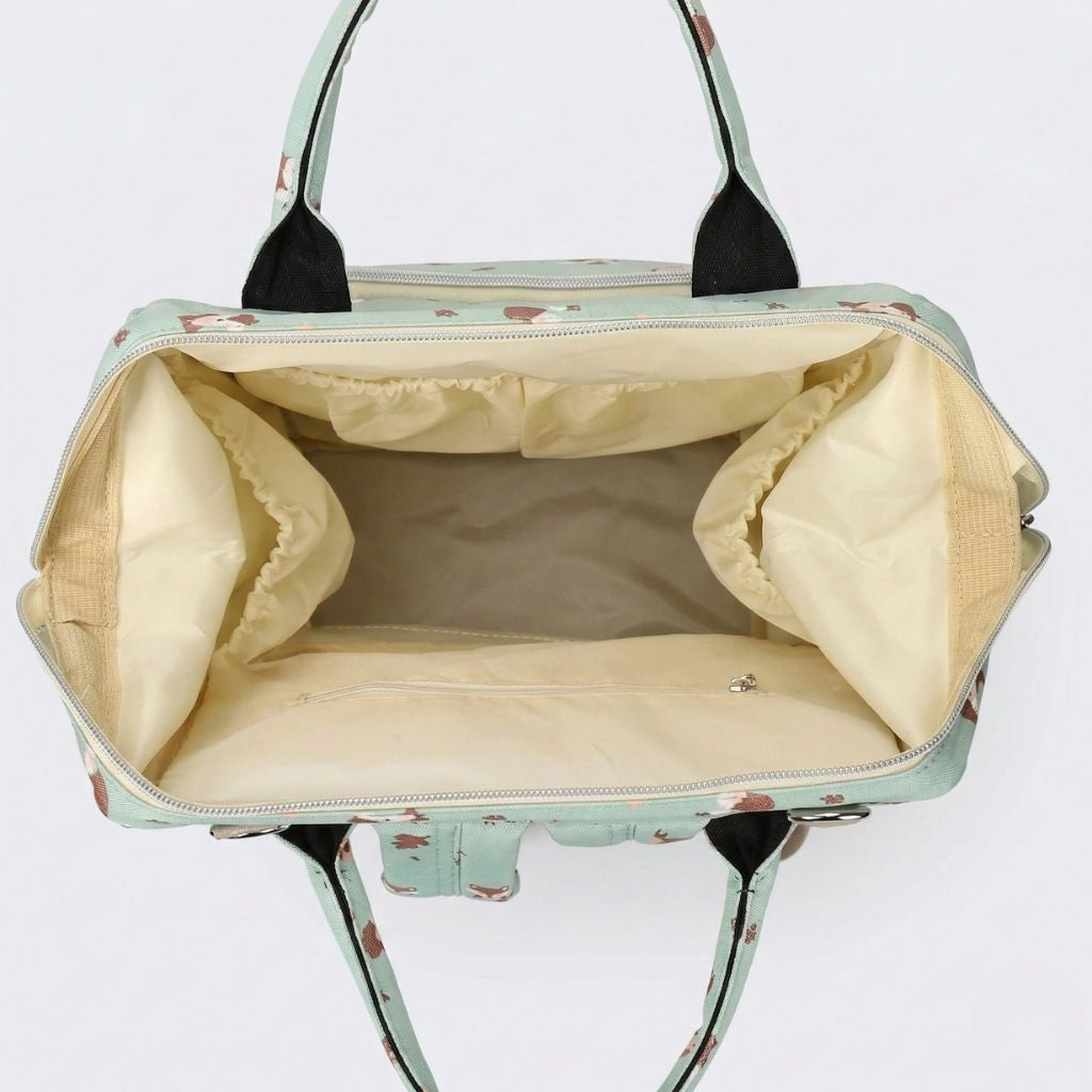 Intérieur vide du sac à langer vert sauge vu de dessus, doublure crème avec séparateurs extensibles