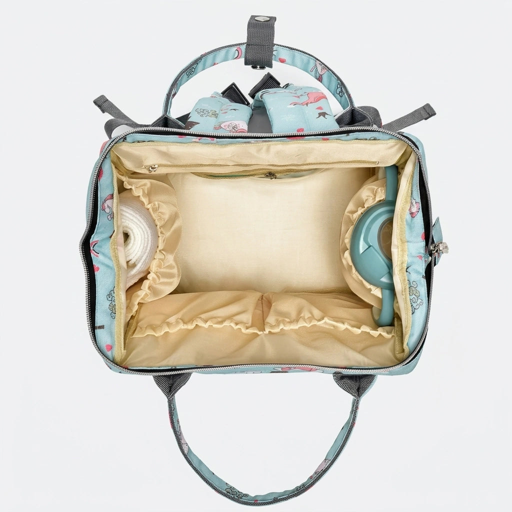 Intérieur du sac à dos à langer vert menthe licornes ouvert en vue plongeante avec matelas à langer