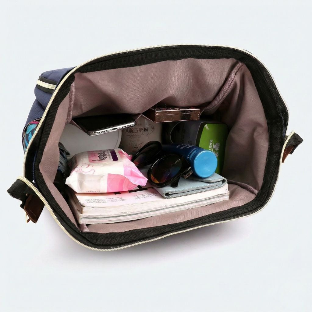 Vue plongeante dans le compartiment principal d'un sac à langer avec lingettes, lunettes de soleil et produits bébé Image