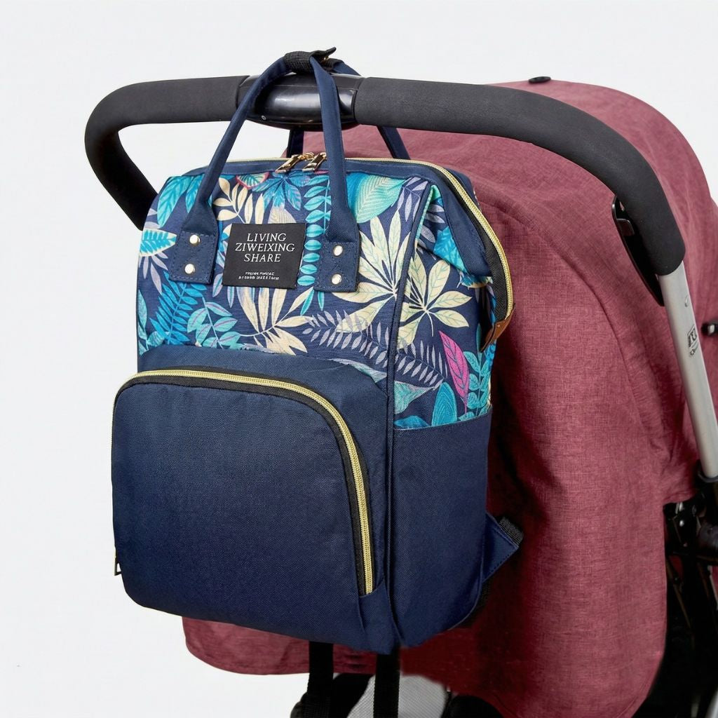 Sac à langer bleu marine à motif tropical accroché par les poignées à une poussette rose bordeaux