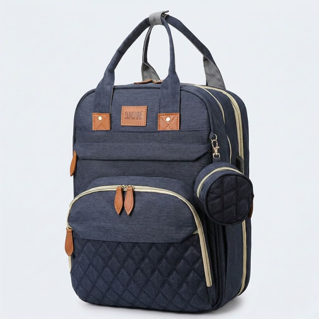 Sac à langer bleu marine vue 3/4 : doubles poignées, poche matelassée diamants, pochette ronde et bandoulière