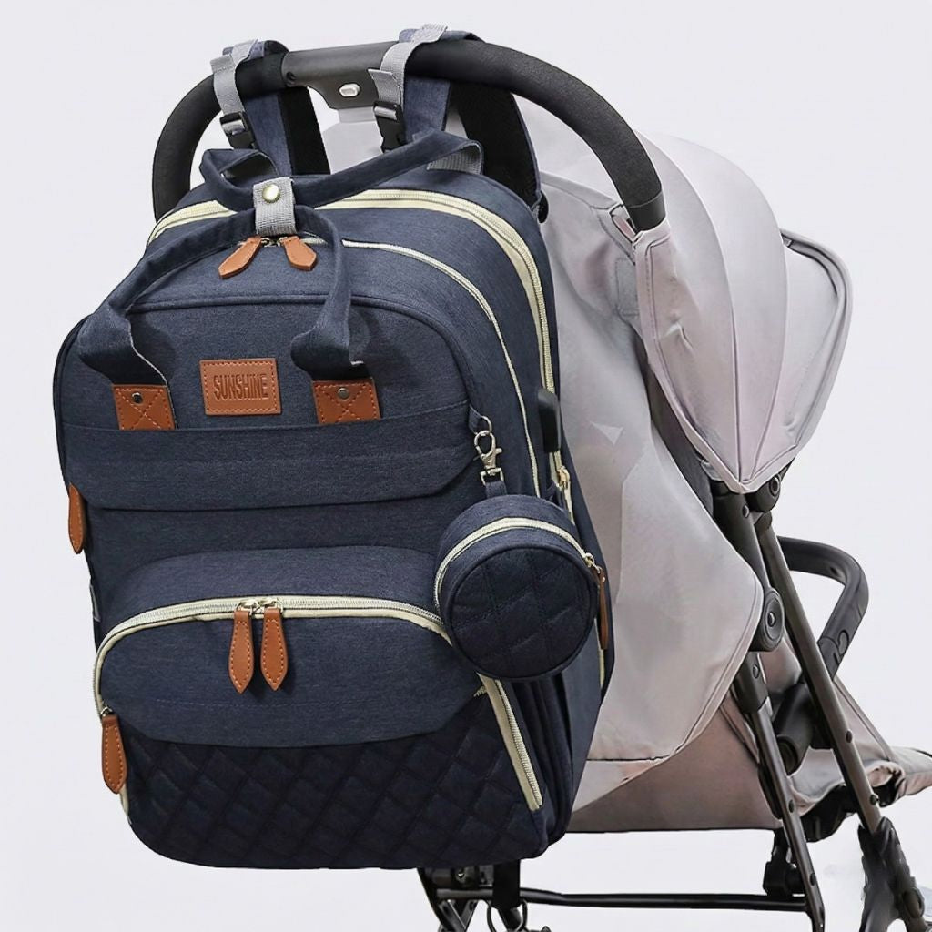 Lifestyle : sac à langer bleu marine accroché par ses poignées sur une poussette grise pour faciliter l'accès Image
