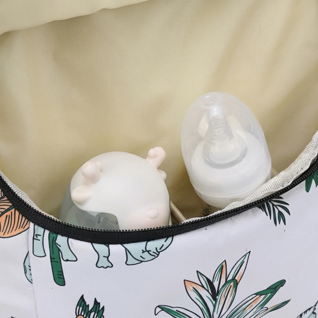 Intérieur spacieux du sac à dos à langer avec tissu imprimé jungle, contenant biberons et jouets bébé en silicone Image