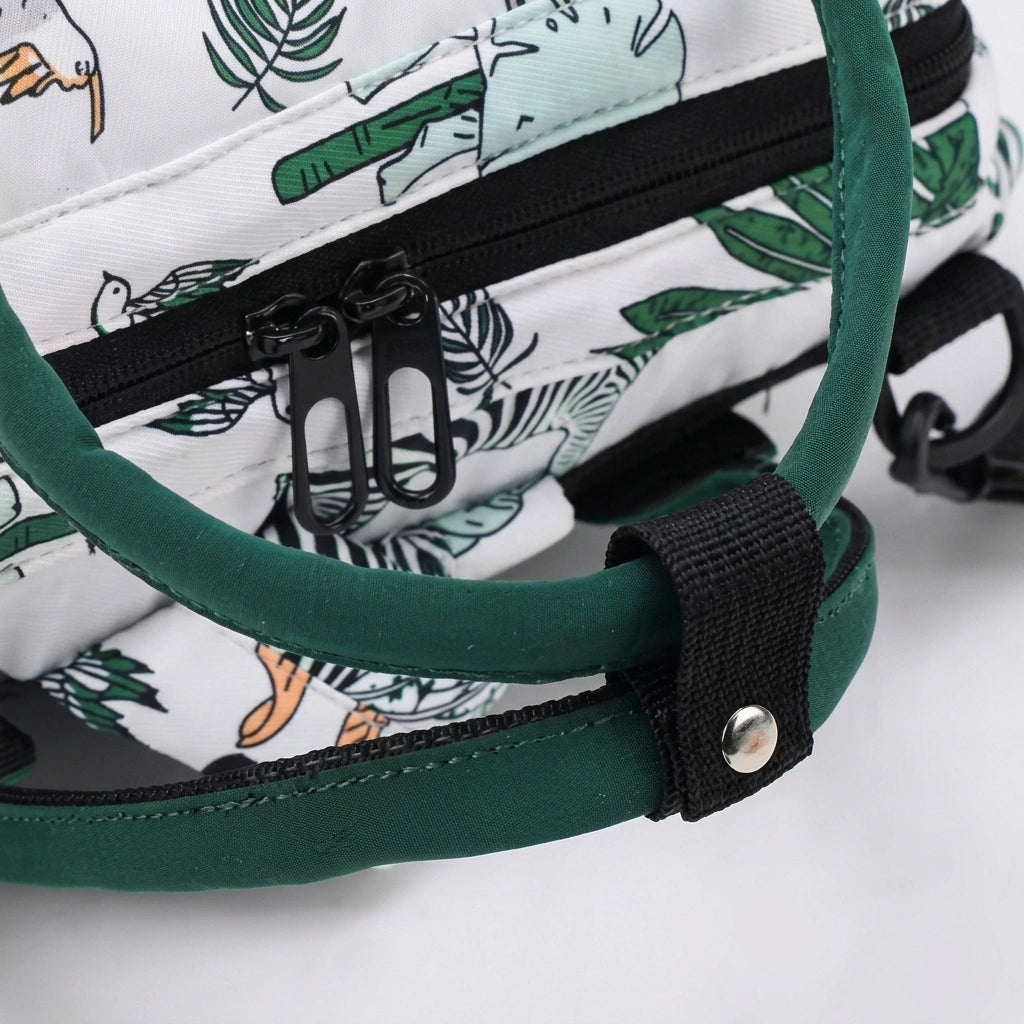 Gros plan des anses vertes et de la fermeture éclair du sac à dos à langer safari, finitions soignées