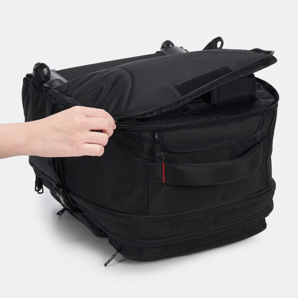 Main ouvrant le couvercle supérieur du sac à roulettes noir posé à plat, accès rapide intérieur