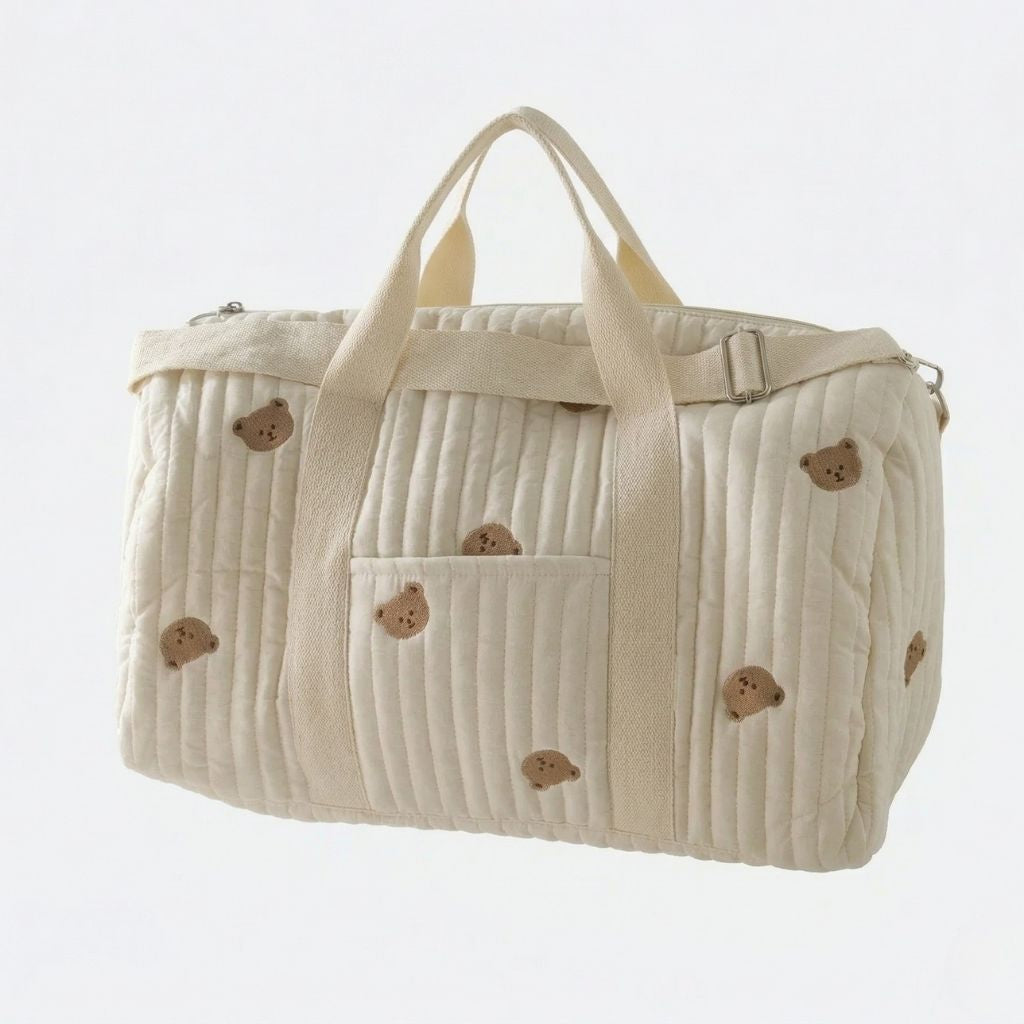 Sac à langer matelassé crème avec ours brodés, vue 3/4, double poignée textile et bandoulière réglable