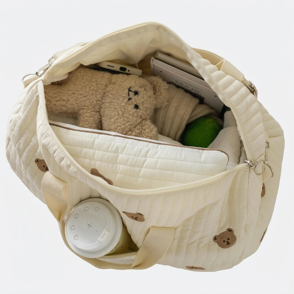 Sac à langer matelassé ourson ouvert, révélant l'intérieur spacieux avec matelas à langer intégré et compartiments