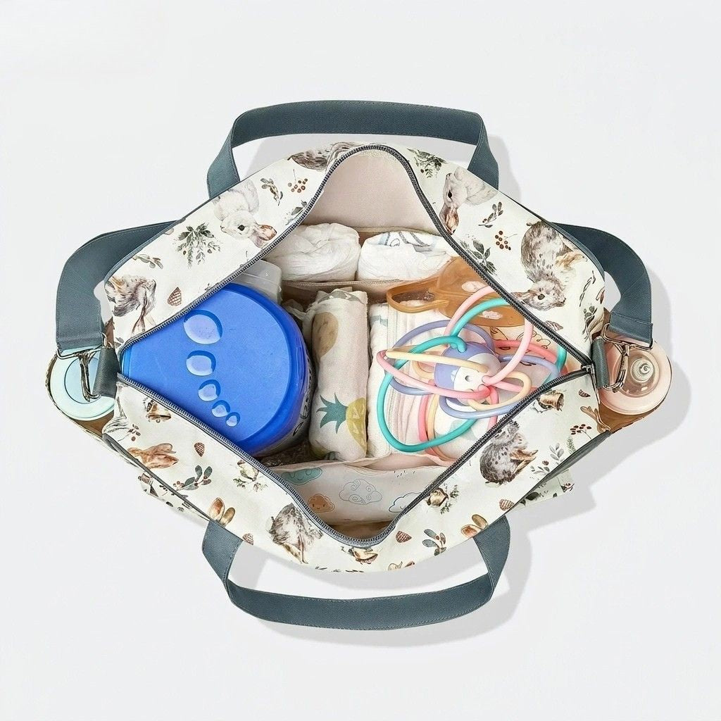 Vue dessus du sac à langer cabas ouvert avec couches, accessoires bébé et jouet, grande capacité
