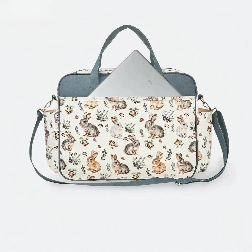 Sac à langer cabas vert pétrole motif lapins, poche arrière ouverte avec ordinateur sorti, polyvalent