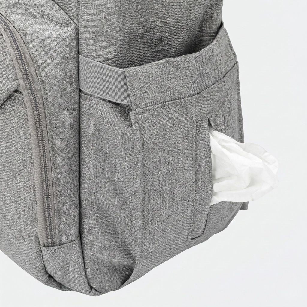 Gros plan de la poche latérale du sac gris chiné avec un paquet de lingettes bébé qui en sort
