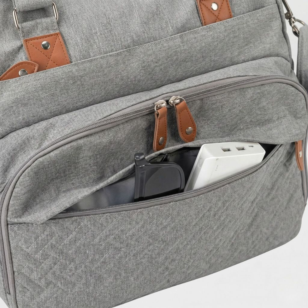 Gros plan de la poche frontale ouverte du sac gris chiné : téléphone et batterie externe rangés