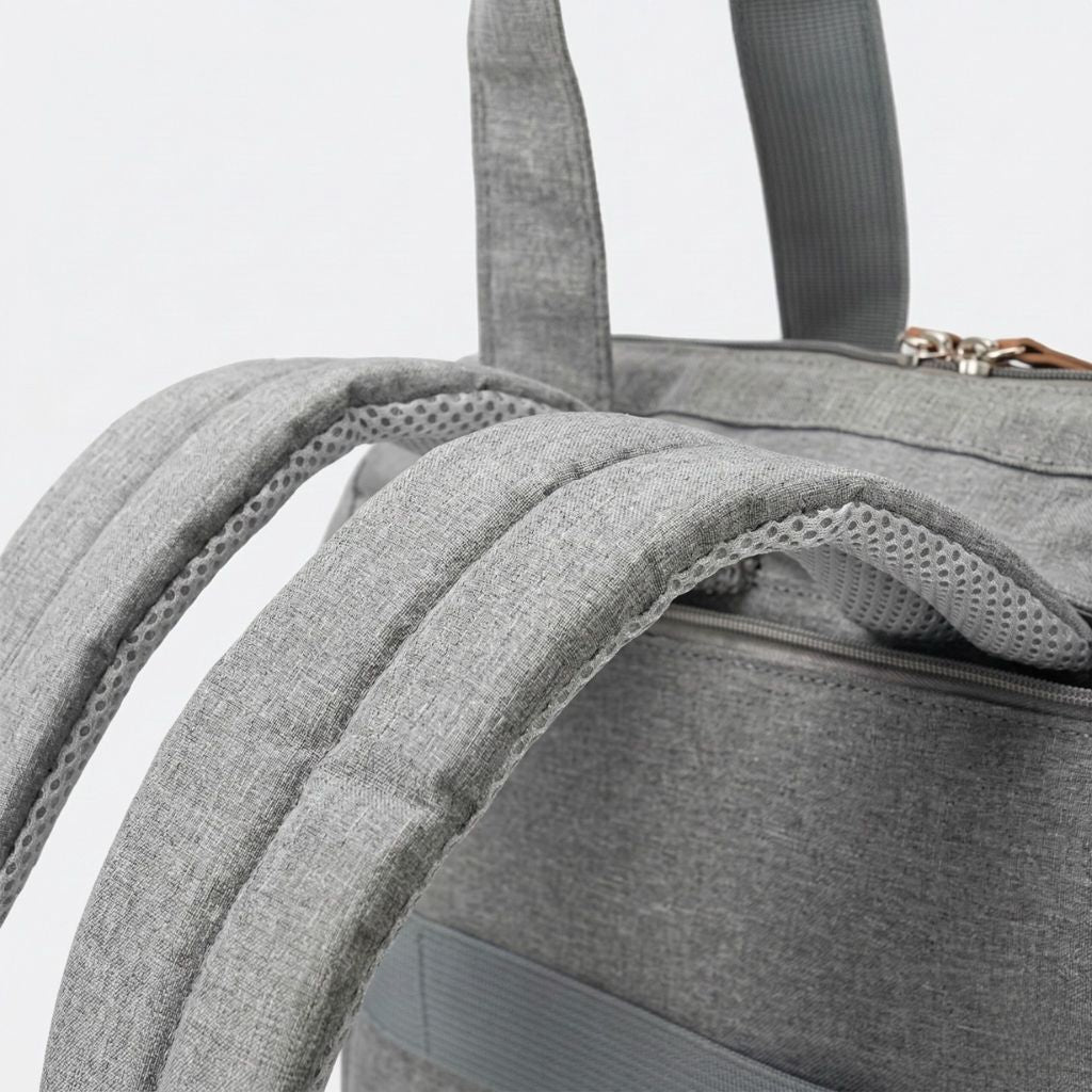 Gros plan des bretelles maillées rembourrées du sac gris chiné en matière honeycomb très aérée