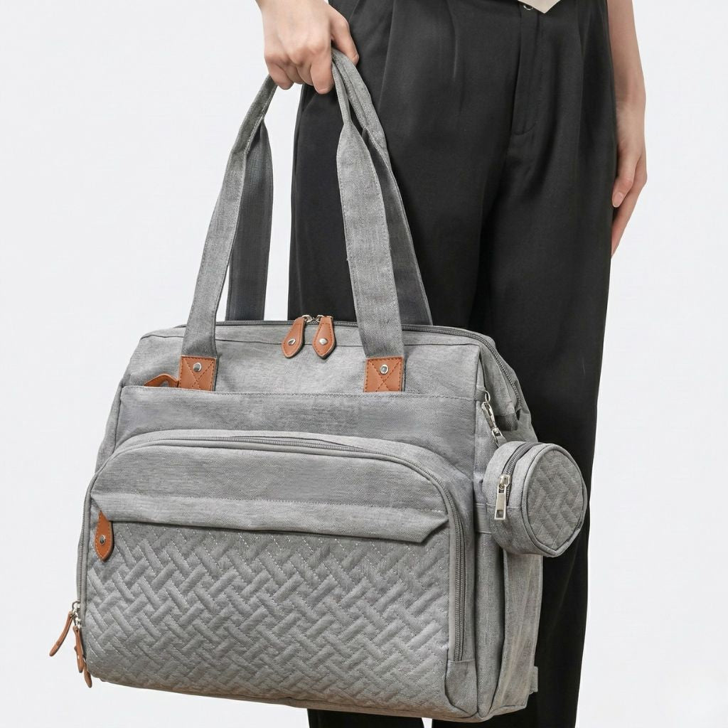 Lifestyle : femme portant le sac gris chiné à la main en mode tote bag, utilisation urbaine au quotidien