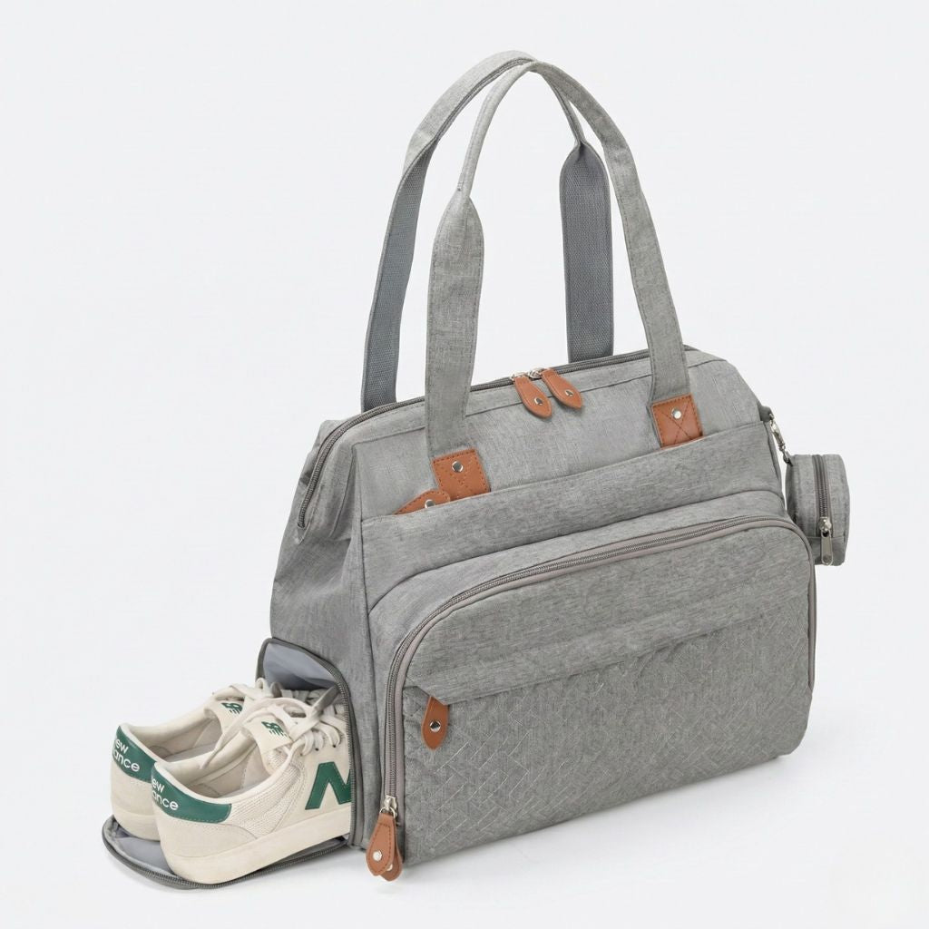 Compartiment chaussures latéral ouvert du sac gris chiné avec basket New Balance sortant partiellement