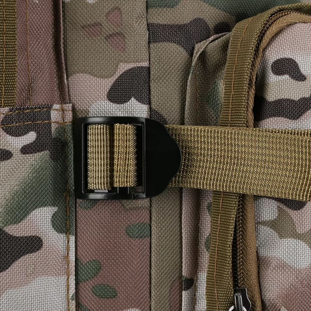 Gros plan sur le clip de compression noir d'un sac à dos tactique en tissu camouflage multicam et sangle coyote.