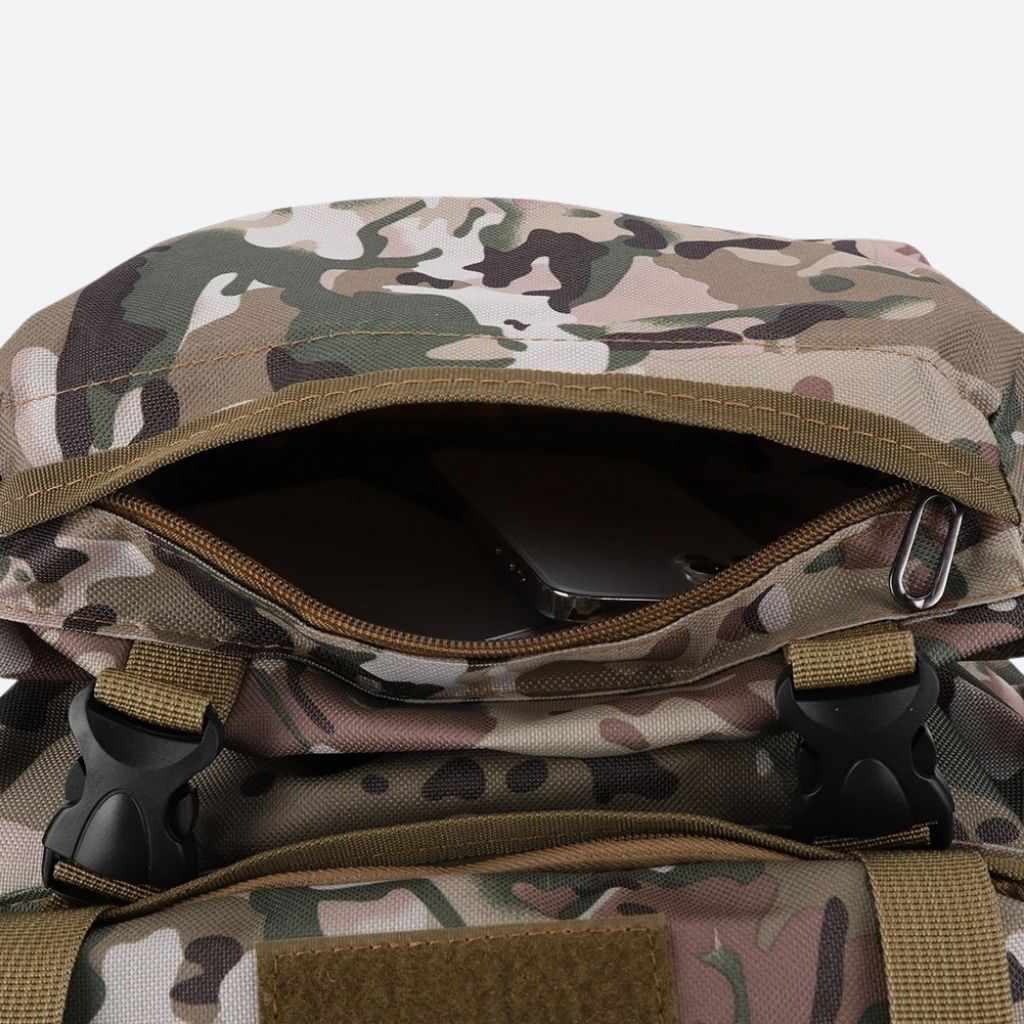 Poche supérieure d'un grand sac à dos tactique en tissu camouflage ouverte avec un smartphone visible Image