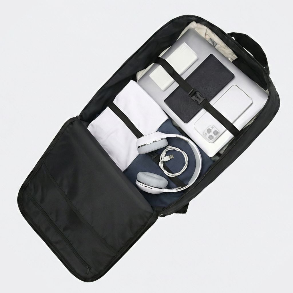 Vue aérienne du sac à dos cabine noir ouvert avec laptop, téléphone, casque, câbles et vêtements