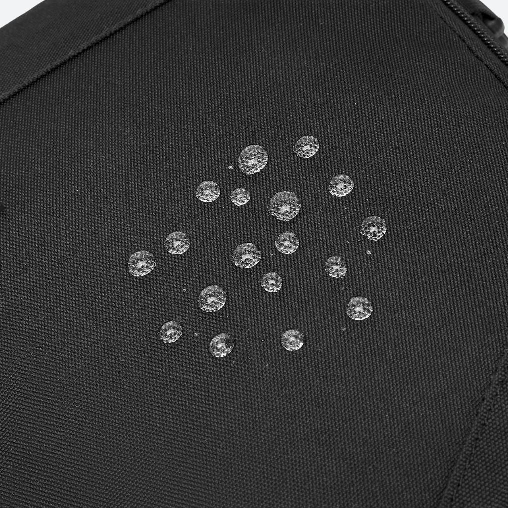 Gros plan sur des gouttes d'eau perlant sur le tissu imperméable traité du sac à dos de voyage