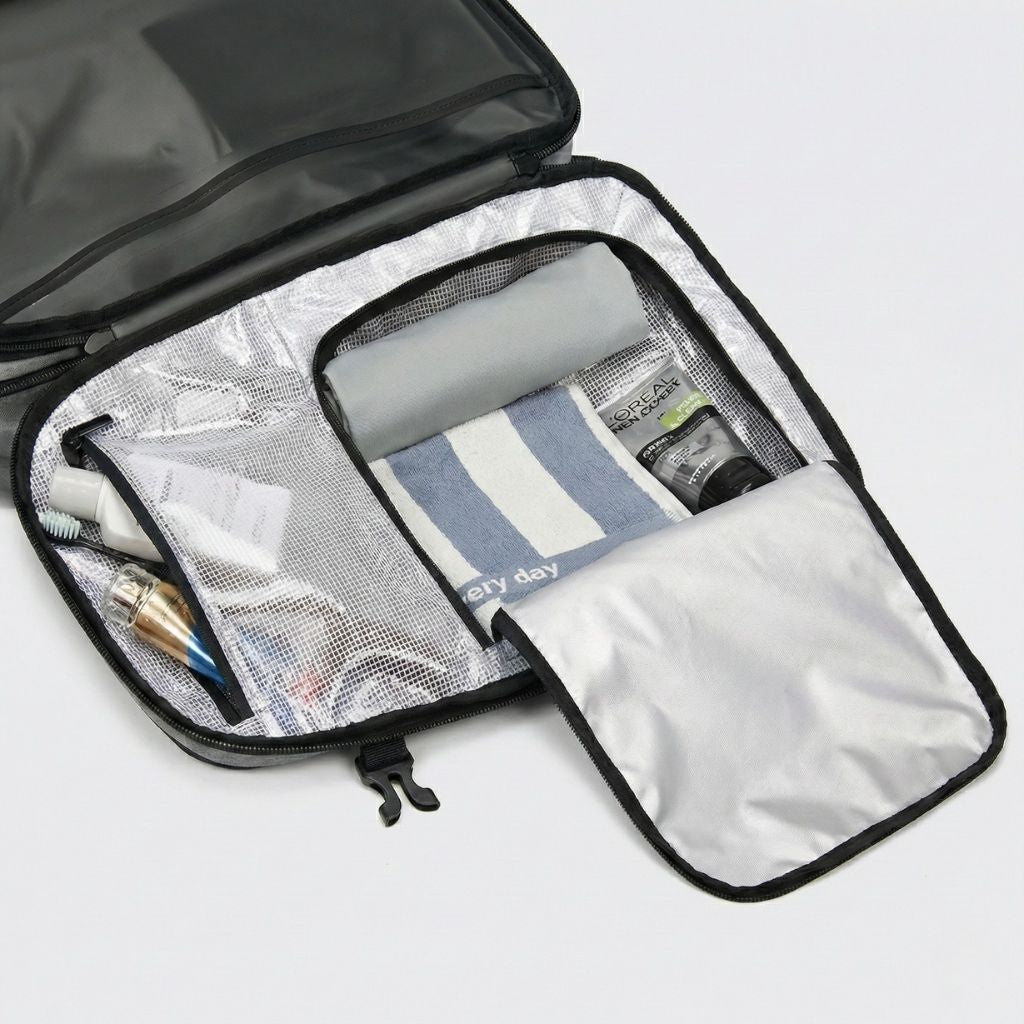 Intérieur du sac à dos gris ouvert, organiseur à filets blancs avec serviette, produits de soin et parfum