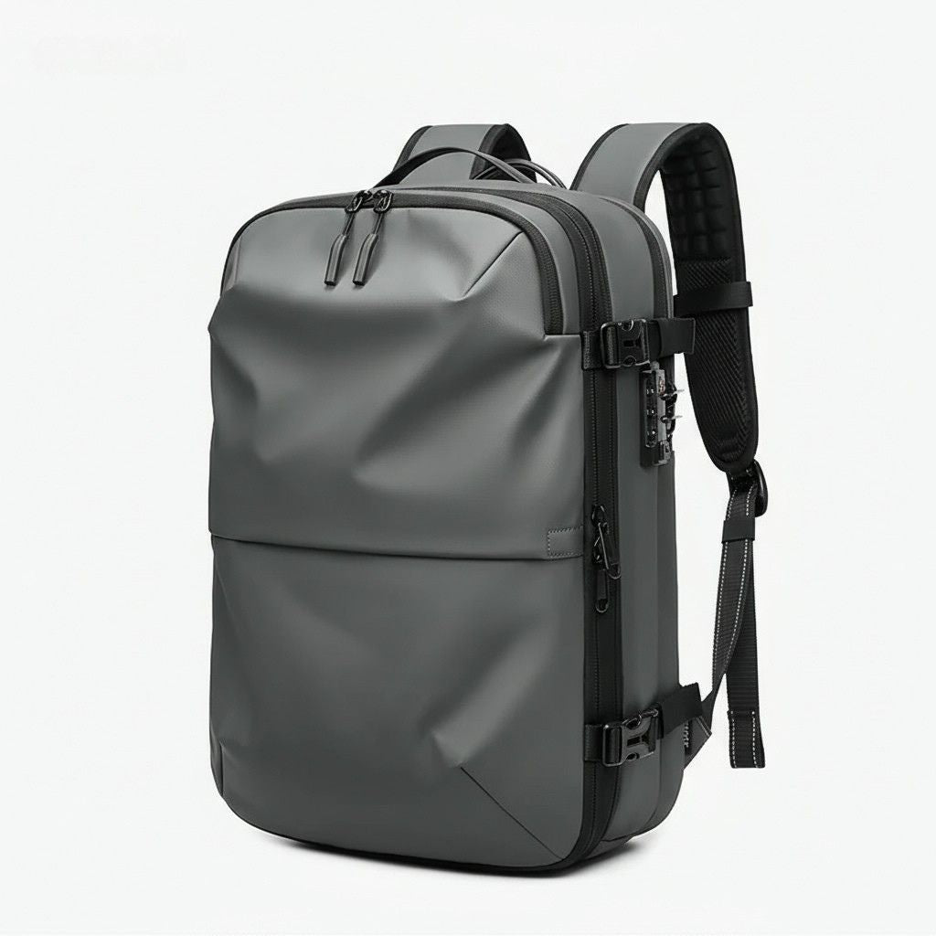 Sac à dos coloris gris foncé vue 3/4, coque semi-rigide aux facettes géométriques mates et serrure latérale